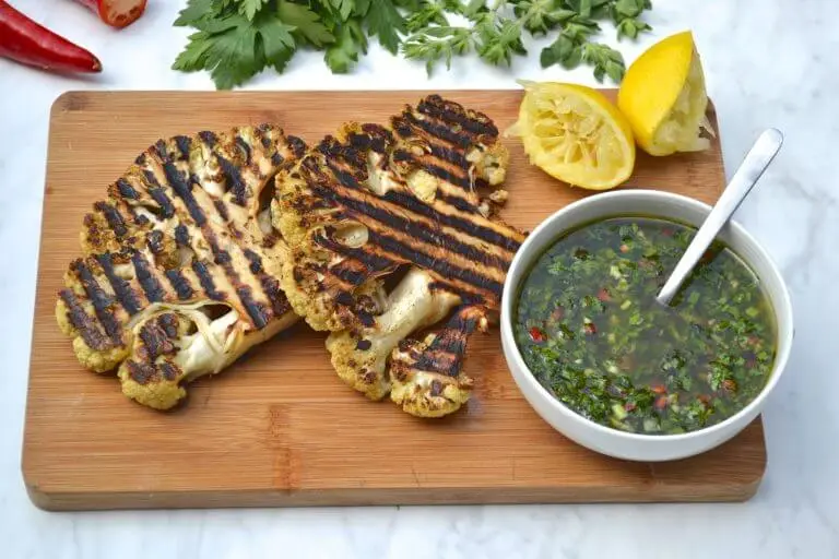 A serving of BBQ cauliflower steak with chimichurri sauce